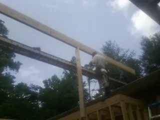 Carpenter setting a ridge beam over a new addition frame — Ice Dam Removal by Roofing Brothers in Simsbury