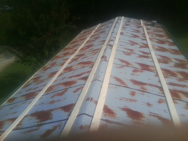 Rusted metal roof panels with new wood purlins before replacement — Storm Damage Roof Repair in Simsbury by Roofing Brothers
