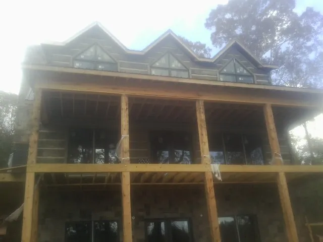 Dormers and porch framing on a large log home under construction — Roof Coating work by our crew in Simsbury