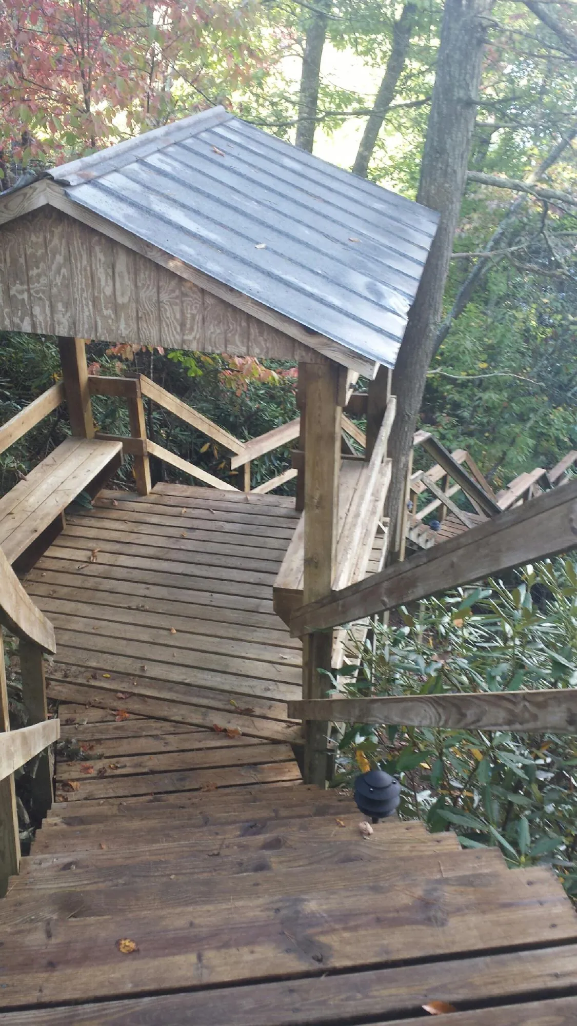 Metal roofed shelter over wooden steps on a wooded walkway — Skylight Repair & Installation work by our crew in Simsbury