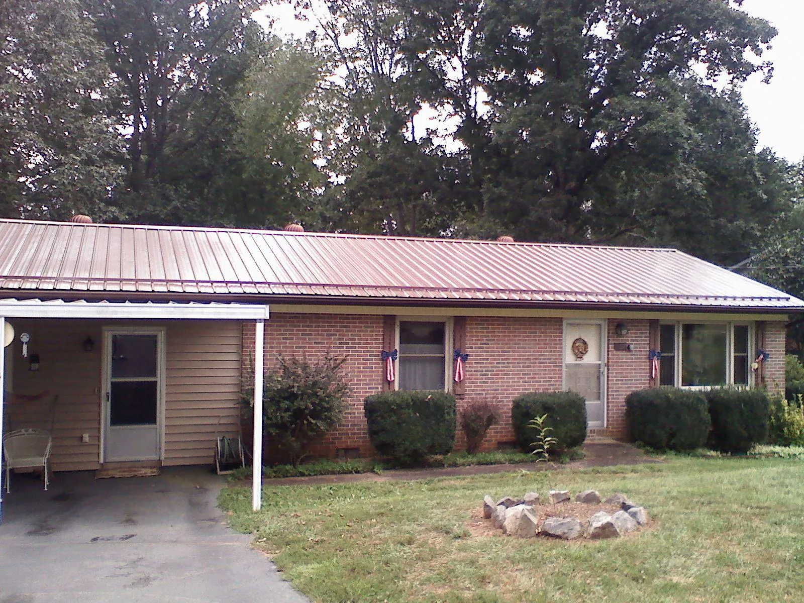 Bronze metal roof and carport on a brick ranch home — Roof Repair work by our crew in Simsbury